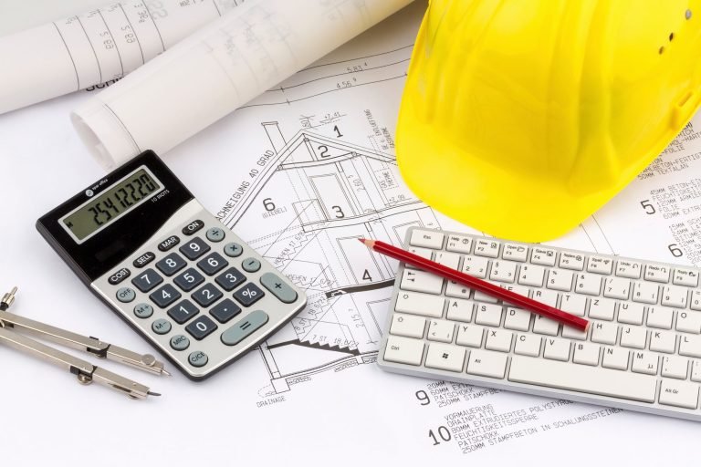 House plan with a construction worker helmet on a desk