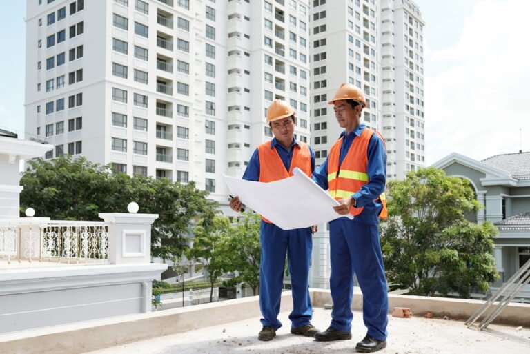 Two site engineers checking a construction plan on a building site