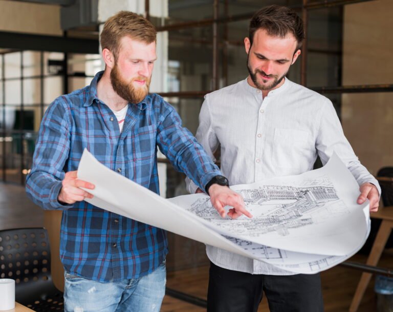 Estimator showing a blueprint to a colleague in the office