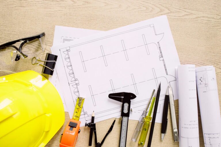 Safety helmet, tools and construction drawings on a desk