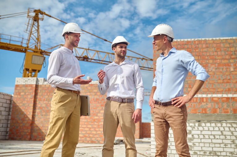 Three construction professionals discussing a project on site